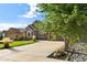 Attractive home featuring a long driveway, well-kept lawn, stone accents, and beautiful trees at 444 Pasada Way, Monument, CO 80132