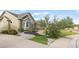 Well-maintained landscaping with vibrant green grass, decorative rock features, and mature trees enhance the property's appeal at 444 Pasada Way, Monument, CO 80132