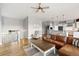 Spacious living room with hardwood floors, a ceiling fan, and views of the kitchen and staircase at 444 Pasada Way, Monument, CO 80132