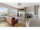 Bright living room with a cozy fireplace, ceiling fan, and natural light from large windows at 444 Pasada Way, Monument, CO 80132