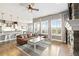 Open-concept living room connecting to kitchen and dining area, featuring a stone fireplace and large windows at 444 Pasada Way, Monument, CO 80132