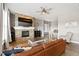 Inviting living room featuring a stone fireplace, ceiling fan, and comfortable leather seating at 444 Pasada Way, Monument, CO 80132