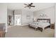 Spacious main bedroom with a ceiling fan, stylish decor, and an open layout to the ensuite bathroom at 444 Pasada Way, Monument, CO 80132