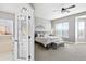 Serene main bedroom with a view of the ensuite bathroom, ceiling fan, and bright windows at 444 Pasada Way, Monument, CO 80132