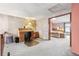 Open bedroom area with a roll-top desk, neutral carpet, and doorway to the sleeping area at 1950 S Helena St # D, Aurora, CO 80013
