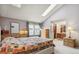 Bedroom with a colorful quilt, light gray walls, and large sunny window at 1950 S Helena St # D, Aurora, CO 80013