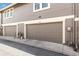Garage doors with unit numbers, side-by-side, on a condominium exterior with a neutral color scheme at 1950 S Helena St # D, Aurora, CO 80013