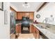 Modern kitchen with stainless steel refrigerator, granite counters, and hardwood floors at 1950 S Helena St # D, Aurora, CO 80013