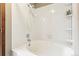 White tiled bathtub and shower with built-in shelving at 1950 S Helena St # D, Aurora, CO 80013