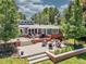 Expansive backyard patio with a fire pit and seating, surrounded by lush landscaping at 5350 Yellowstone St, Bow Mar, CO 80123