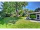 Lush, expansive backyard with mature trees and a well-maintained lawn, perfect for outdoor activities at 5350 Yellowstone St, Bow Mar, CO 80123