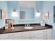 Well-lit bathroom featuring a vanity with granite countertop, framed mirror, and decorative sconces at 5350 Yellowstone St, Bow Mar, CO 80123