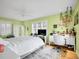 Light and airy bedroom with a white comforter, decorative accents, and a bright green wall at 5350 Yellowstone St, Bow Mar, CO 80123