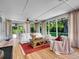Sunroom with bright, natural light, comfortable seating, wood floors and views of lush greenery at 5350 Yellowstone St, Bow Mar, CO 80123