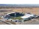 Aerial view of a stadium, roads, and fields with the Rocky Mountains in the distance at 8742 E 47Th Ave, Denver, CO 80238
