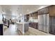 Open-concept kitchen with stainless steel appliances, center island, and an adjacent living room with a staircase at 8742 E 47Th Ave, Denver, CO 80238