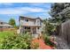 Charming back exterior features a covered patio and meticulously landscaped garden at 6643 Orion Ct, Arvada, CO 80007