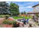 Beautiful backyard features a custom patio with a fire pit and lush, mature landscaping at 6643 Orion Ct, Arvada, CO 80007