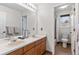 Well-lit bathroom with double vanity, large mirror, and separate toilet/shower area at 6643 Orion Ct, Arvada, CO 80007