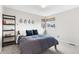 Bright bedroom with big window, and stylish blue bedding with an interesting decorative wall piece at 6643 Orion Ct, Arvada, CO 80007