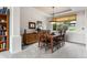Traditional dining room features carpet, a wooden table with six chairs, and a large window for natural light at 6643 Orion Ct, Arvada, CO 80007