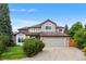 Two-story home with brick accents, a well-manicured lawn, and a two-car garage on a sunny day at 6643 Orion Ct, Arvada, CO 80007