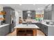 Stylish kitchen featuring gray cabinets, stainless appliances, and a wood-accented island with seating at 6643 Orion Ct, Arvada, CO 80007