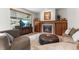 Inviting living room featuring a fireplace, wood mantle, and a large window with outdoor views at 6643 Orion Ct, Arvada, CO 80007