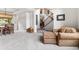 Cozy living room featuring a comfortable chair and view into the adjacent dining and staircase at 6643 Orion Ct, Arvada, CO 80007