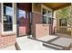 Charming front porch with brick accents, a storm door, and a well-lit entryway on a sunny day at 11896 Meade Ct, Westminster, CO 80031