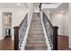 Staircase featuring wood stairs, a dark wood banister and metal spindles, offering a stylish transition between floors at 11896 Meade Ct, Westminster, CO 80031
