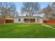 A spacious backyard view showcasing the house, green lawn, and wood deck at 3342 S Flamingo Way, Denver, CO 80222