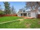 Spacious backyard with lush green grass, wood deck, and privacy fence at 3342 S Flamingo Way, Denver, CO 80222