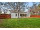 A serene backyard with a lush lawn, mature trees, and partial fencing at 3342 S Flamingo Way, Denver, CO 80222