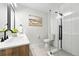 Modern bathroom includes double sink vanity with black fixtures and a glass-enclosed shower for a spa-like experience at 3342 S Flamingo Way, Denver, CO 80222