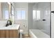 Bright bathroom features a modern vanity, sleek fixtures, and a bathtub-shower combo with glass screen for a clean and airy feel at 3342 S Flamingo Way, Denver, CO 80222