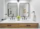 Bright bathroom boasts double sinks, wood cabinets, black fixtures, and modern mirrors, creating a stylish and functional space at 3342 S Flamingo Way, Denver, CO 80222