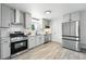 Bright kitchen boasts stainless steel appliances, gray cabinets, and white subway tile backsplash at 3342 S Flamingo Way, Denver, CO 80222