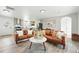 Open-concept kitchen and living area with hardwood floors, stylish furniture, and white cabinets at 3342 S Flamingo Way, Denver, CO 80222