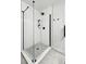 Stylish walk-in shower features frameless glass, black hardware, gray floor, and modern tile, providing an elegant and open feel at 3342 S Flamingo Way, Denver, CO 80222