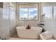 Bathroom featuring a modern soaking tub, marble-tiled walls, and black fixtures at 4211 Vallejo St, Denver, CO 80211