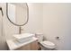 Minimalist powder room with modern sink, unique mirror, and a toilet with sleek fixtures at 4211 Vallejo St, Denver, CO 80211