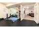 Basement gym with mirrored wall, exercise equipment, and view into adjacent room at 2453 Reserve St, Erie, CO 80516