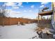 Home's backyard has a wood fence, some snow, and utility equipment in view at 20054 E 48Th Dr, Denver, CO 80249