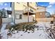 The back of the home offers a balcony, a sliding door for entry, and a snowy lawn at 20054 E 48Th Dr, Denver, CO 80249