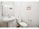 Powder room with pedestal sink, toilet, and decorative artwork at 20054 E 48Th Dr, Denver, CO 80249