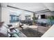 Cozy living room with large window, leather sofas, plants, and mounted television at 20054 E 48Th Dr, Denver, CO 80249