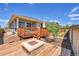 Backyard deck featuring a fire pit and a view of the surrounding trees and landscaping at 3086 Kestrel St, Brighton, CO 80601