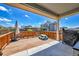 Inviting outdoor deck with wooden railing, seating and a view of the surrounding neighborhood at 3086 Kestrel St, Brighton, CO 80601