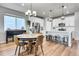 Dining room with a round table, views to the kitchen, with stainless steel appliances and white cabinets at 3086 Kestrel St, Brighton, CO 80601